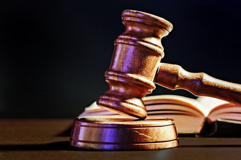 Wooden Gavel And Open Law Book On Desk 